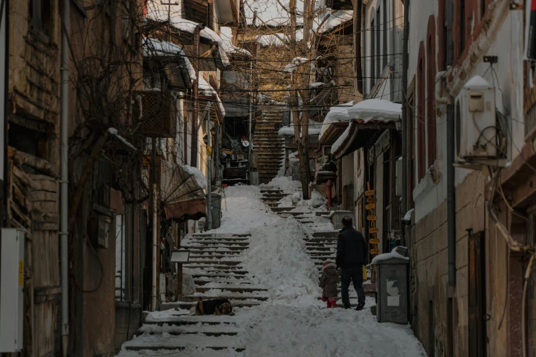 a couple of people walking down a snow covered street, staircases, can basdogan, shady alleys, 1 petapixel image