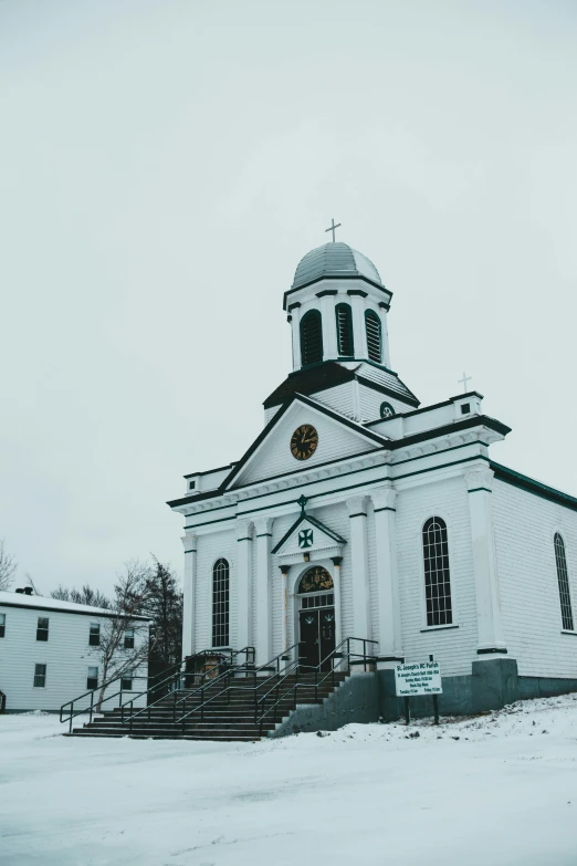 a church sitting in the middle of a snow covered field, white building, nostalgic vibes, built on a steep hill, exterior