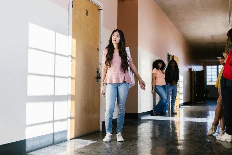 a group of people walking down a hallway, trending on pexels, happening, young asian girl, standing in corner of room, high school, exasperated