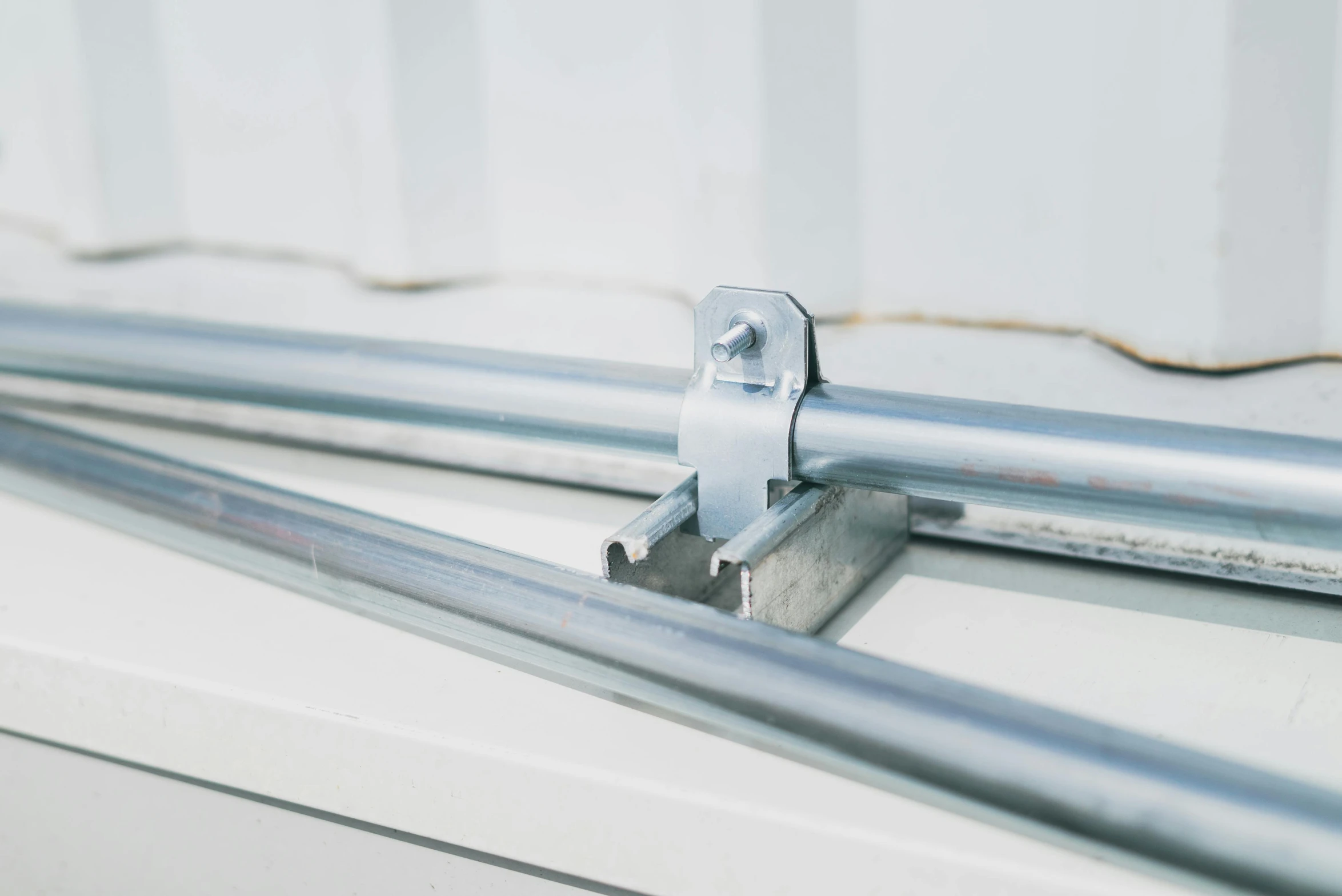 a couple of metal bars sitting on top of a window sill, detailed product image, rounded roof, connector, racking focus