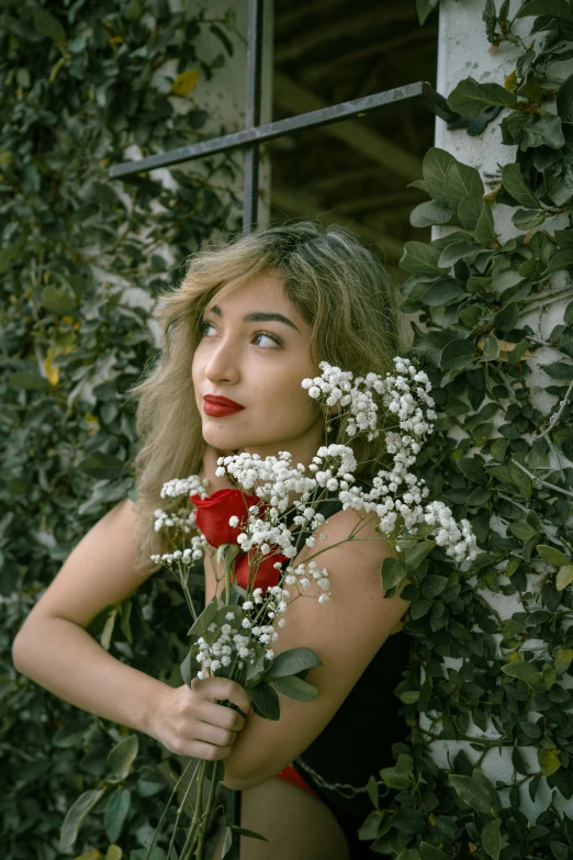 a woman holding a bunch of flowers in front of a window, inspired by Elsa Bleda, trending on pexels, renaissance, red lips, beautiful iranian woman, covered in vines, asian female