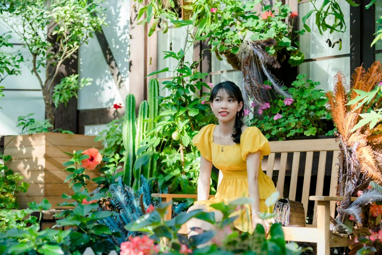 a woman sitting on a bench in a garden, inspired by Kim Jeong-hui, pexels contest winner, wearing a yellow dress, avatar image, ulzzang, indoor picture