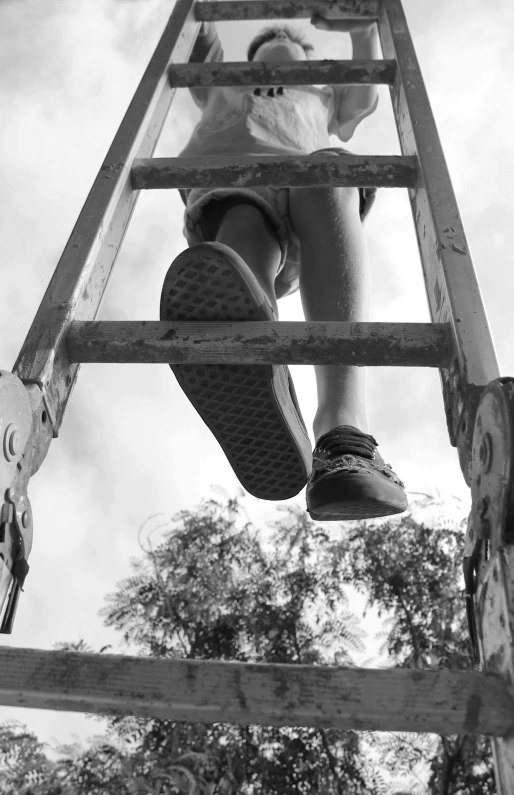 a black and white photo of a child climbing a ladder, unsplash, realism, sneaker photo, view from below, sitting in a crane, traps