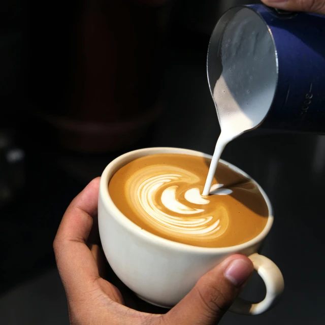 a person pouring milk into a cup of coffee, by Robbie Trevino, pexels contest winner, hurufiyya, bangalore, blue, finely detailed, thumbnail