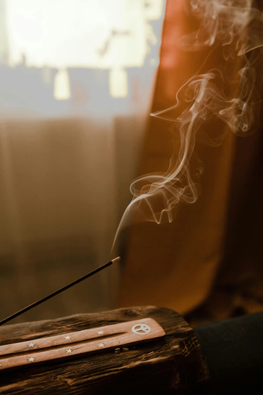 a close up of a incense stick with smoke coming out of it, renaissance, a still of an ethereal, comfy ambience, 王琛, brown