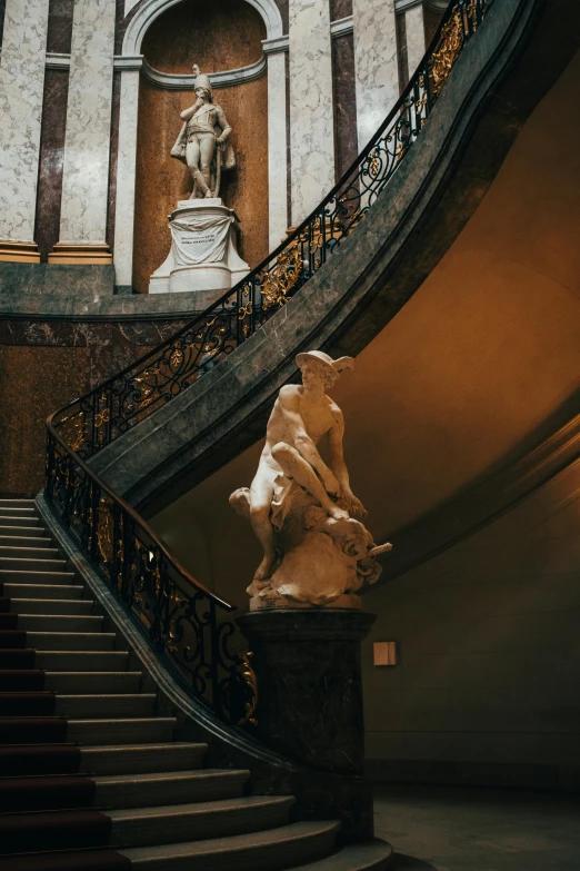 a statue sitting on top of a set of stairs, by Daniel Seghers, pexels contest winner, neoclassicism, curved hallways, baroque color scheme, 1910s architecture, while marble