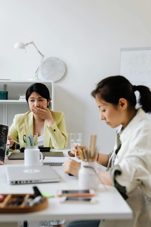 a group of people sitting around a white table, frustrated face, asian women, sitting at a computer, multiple stories