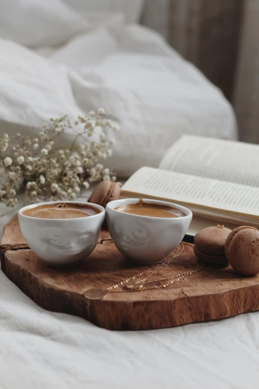 two cups of coffee sitting on top of a wooden tray, unsplash contest winner, romanticism, light beige pillows, storybook style, chocolate, manuka