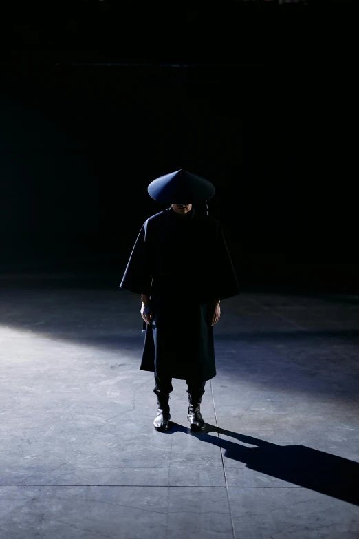 a person that is standing in the dark, an album cover, inspired by Yu Zhiding, ferred - themed robes and hat, runway photo, ninja, showstudio