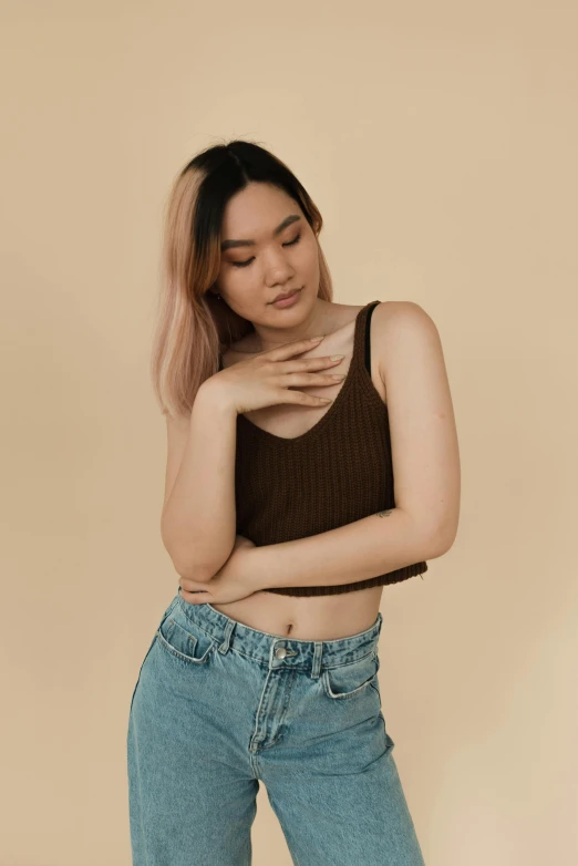 a woman wearing jeans and a tank top, an album cover, by Jason Chan, trending on pexels, brown:-2, gongbi, non binary model, indonesia