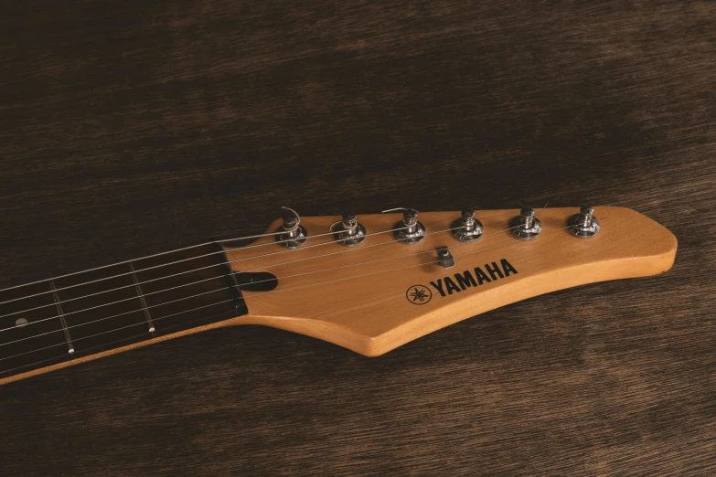 a guitar sitting on top of a wooden table, v - fin, detailed product image, brown, detail shot