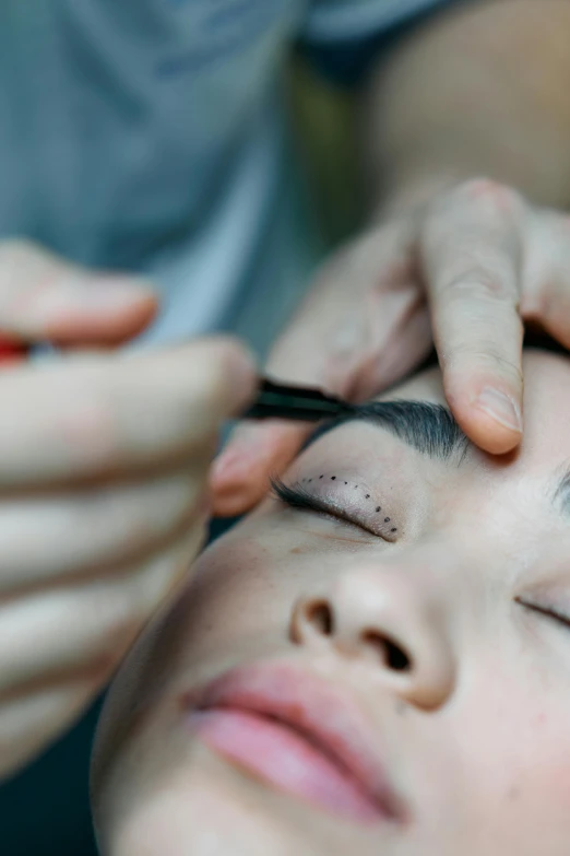 a woman getting her eyebrows done by a hair stylist, trending on pexels, jimin\'s right eyelid swollen, low - angle shot, malaysian, high angle shot