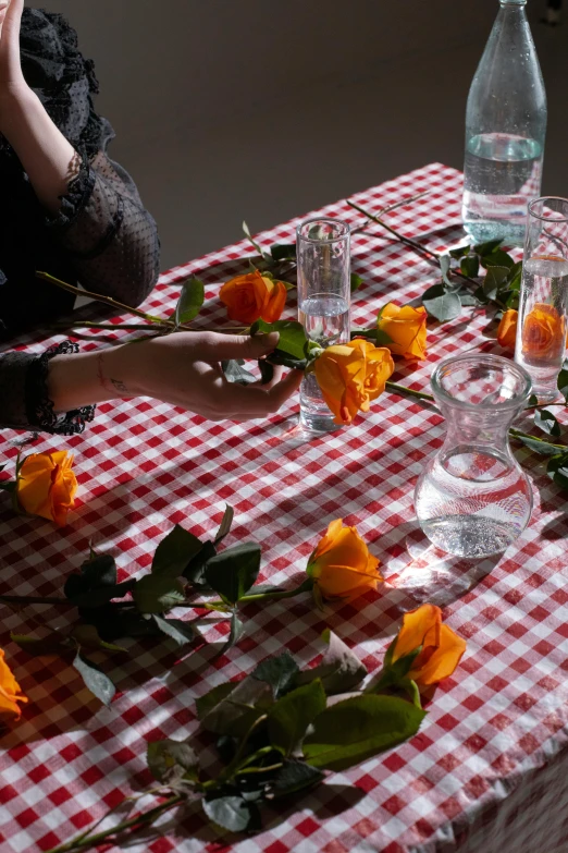 a woman sitting at a table with flowers on it, glassware, photographed for reuters, vines and flowers, detail shot