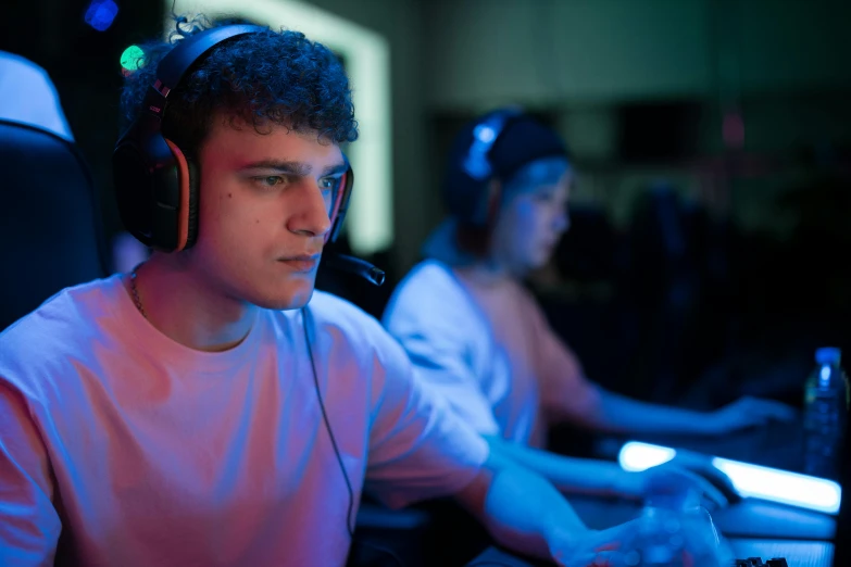 a man wearing headphones sitting in front of a computer, esports, profile image, medium shot of two characters, focused photo