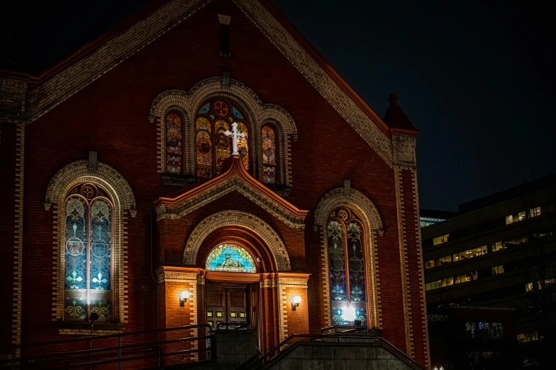 a red brick church lit up at night, a photo, by Meredith Dillman, pexels contest winner, renaissance, orthodoxy, stained glass, exterior photo, night life