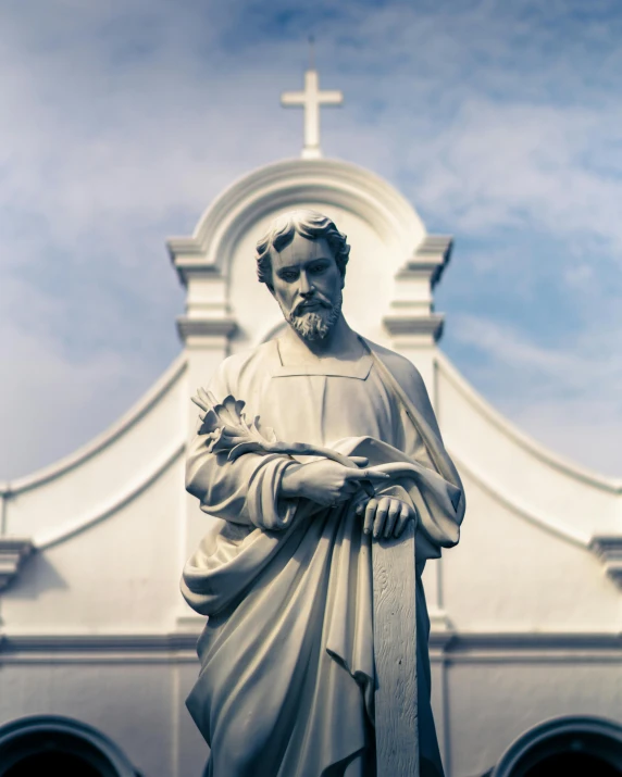 a statue of a man holding a bird in front of a church, unsplash, mannerism, catholic icon, sri lanka, chemistry, grey