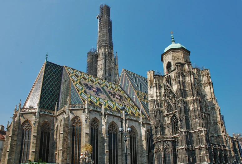 a large cathedral with a clock on it's side, an album cover, by Karel Dujardin, pexels contest winner, austrian architecture, tiled roofs, two giant towers, gold and steel intricate