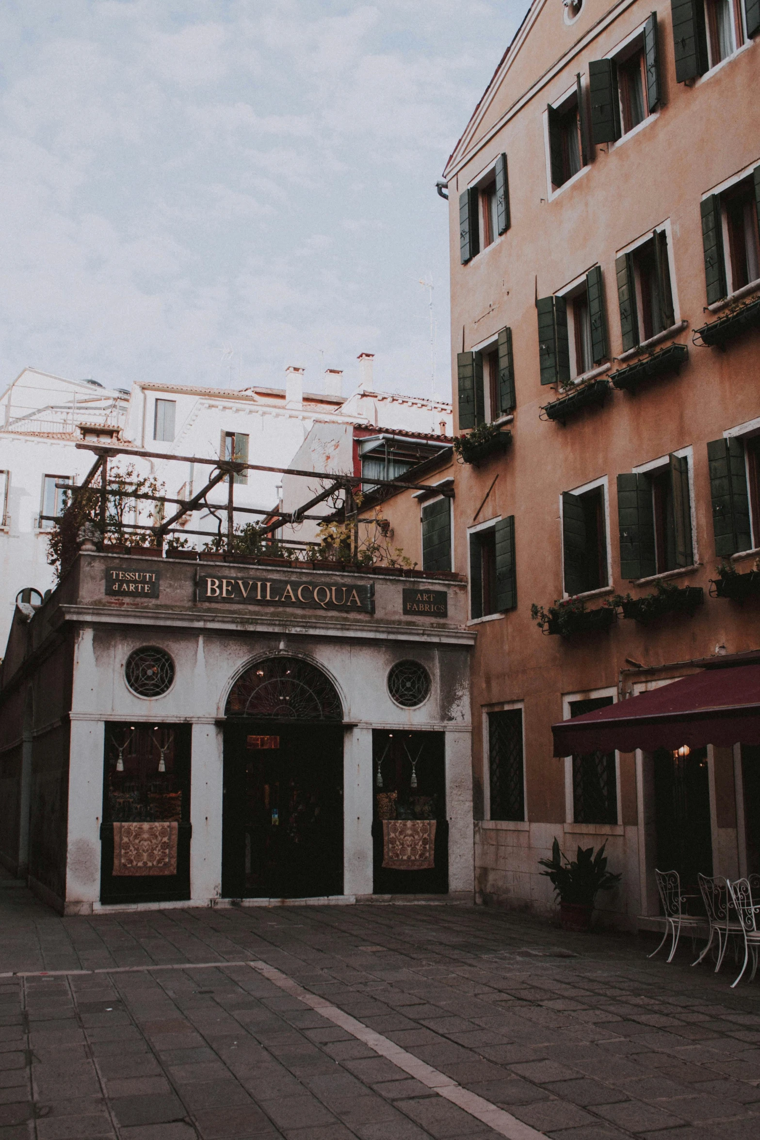 a couple of buildings that are next to each other, an album cover, pexels contest winner, renaissance, cafe, italian style, low quality photo, exterior photo