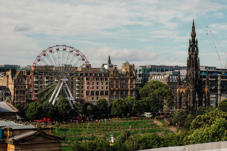 a ferris wheel sitting on top of a lush green field, by Adam Bruce Thomson, pexels contest winner, edinburgh castle, city square, city rooftop, 2 0 0 0's photo