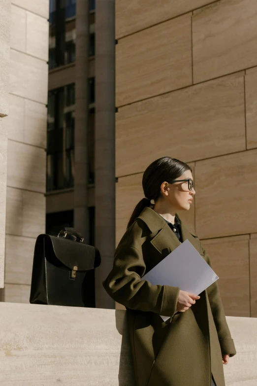 a woman walking down the steps of a building, trending on pexels, lawyer clothing, holding notebook, androgynous person, an asian woman