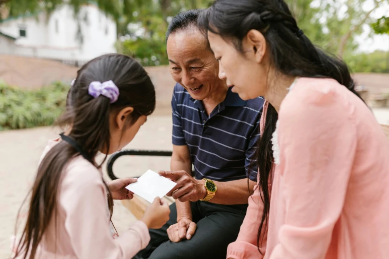 a couple of people that are sitting on a bench, families playing, holding an ace card, louise zhang, caring fatherly wide forehead