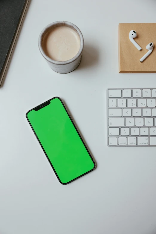 a cell phone sitting on top of a desk next to a keyboard, trending on pexels, color field, black and green, square, no - text no - logo, adafruit