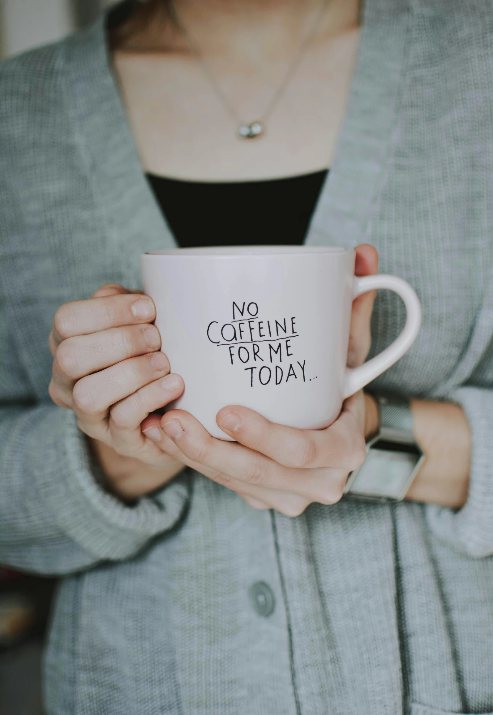 a close up of a person holding a cup, by Nicolette Macnamara, pexels, in white lettering, corinne day, with no problems, contain