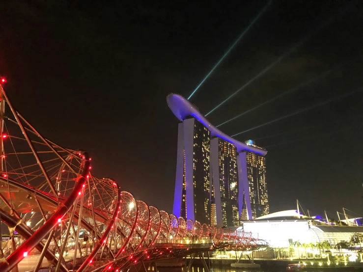 a bridge over a body of water at night, inspired by Zha Shibiao, pexels contest winner, singapore esplanade, red trusses, norman foster, profile picture 1024px