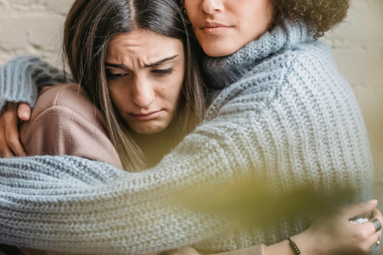 two women hugging each other in front of a brick wall, trending on pexels, renaissance, depressed sad expression, woman holding another woman, multi-part, cosy