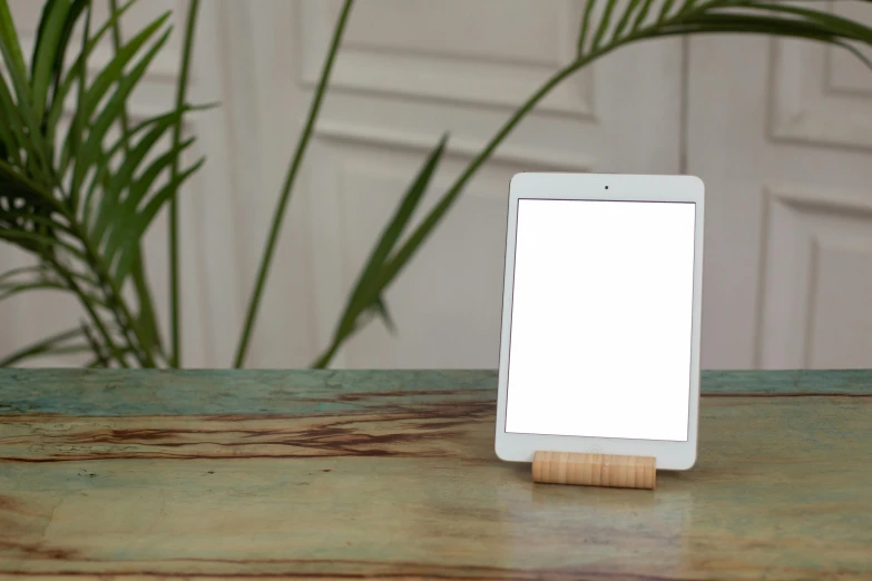 a tablet computer sitting on top of a wooden table, a portrait, inspired by Isamu Noguchi, unsplash, computer art, light frame, square, white light, lighting 8k