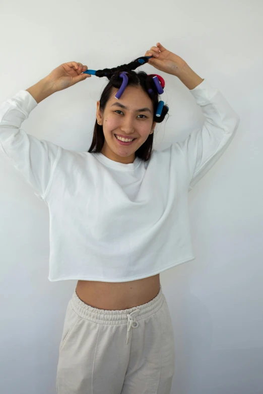 a woman brushing her hair with a pair of scissors, inspired by Kim Jeong-hui, crop top, 3/4 front view, physical : tinyest midriff ever, wearing a white sweater