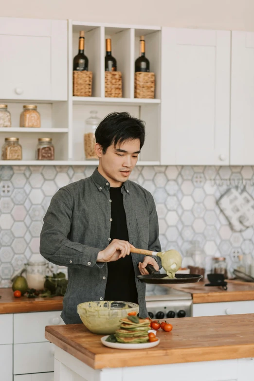 a man standing in a kitchen preparing food, inspired by Zhou Chen, profile image, spoon placed, asian male, grey