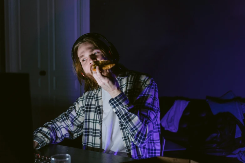 a man sitting at a table eating a donut, a portrait, inspired by Elsa Bleda, unsplash, led gaming, performing a music video, during the night, wearing a flannel shirt