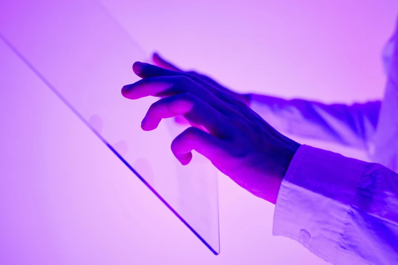 a close up of a person holding a piece of glass, inspired by Yves Klein, unsplash, interactive art, gradient light purple, digital medical equipment, panels, using a magical tablet