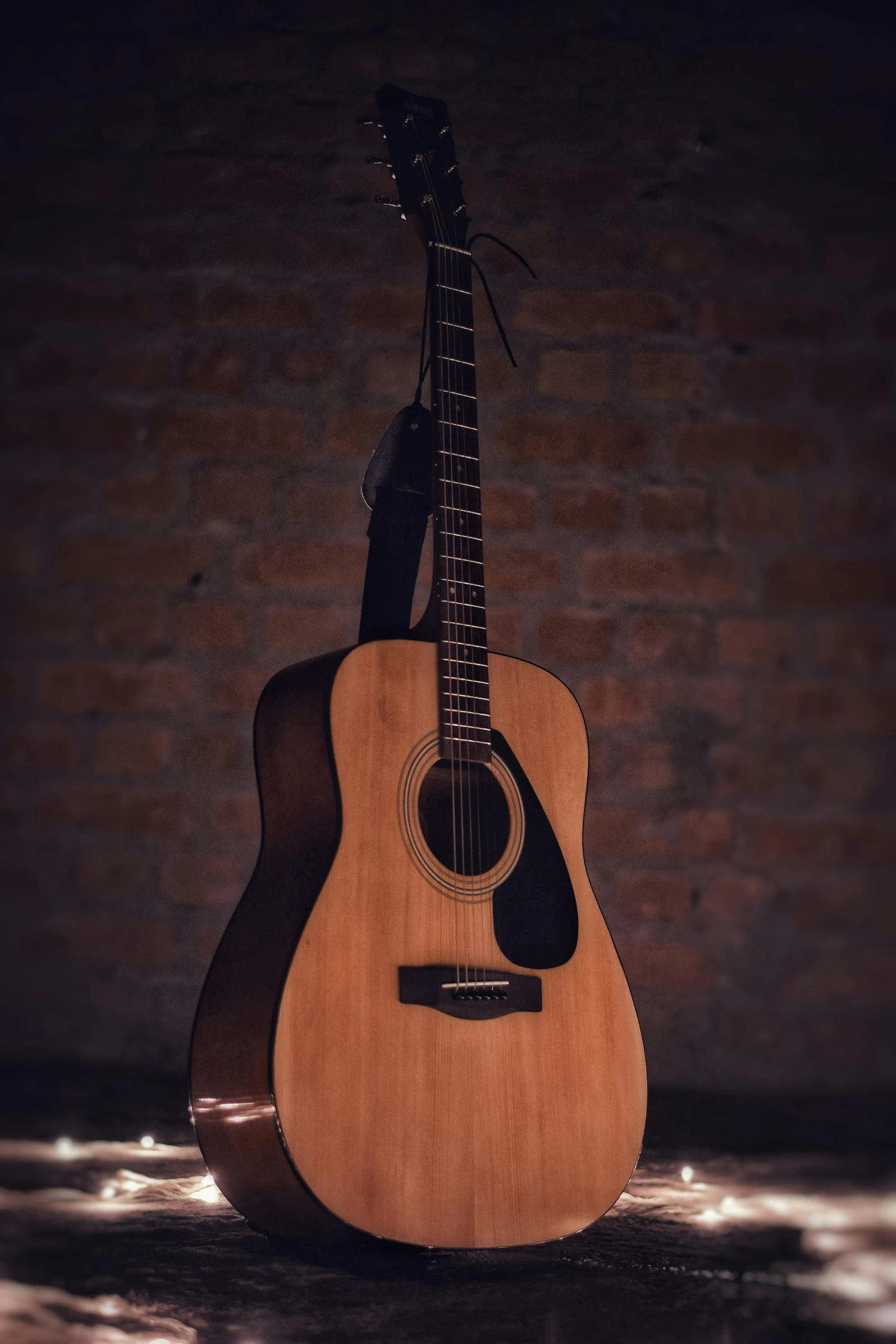 a guitar sitting in front of a brick wall, on a wooden table, profile picture, promo image, no - text no - logo