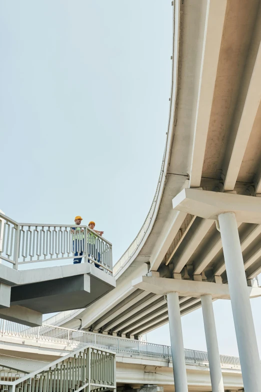 a couple of people standing on top of a bridge, curvilinear architecture, worksafe. instagram photo, pillars, highway
