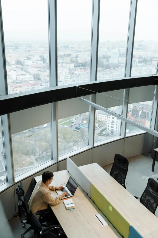 a man sitting at a desk in an office, by Sebastian Vrancx, unsplash contest winner, bauhaus, view over city, 360 degree view, warsaw, in an call centre office