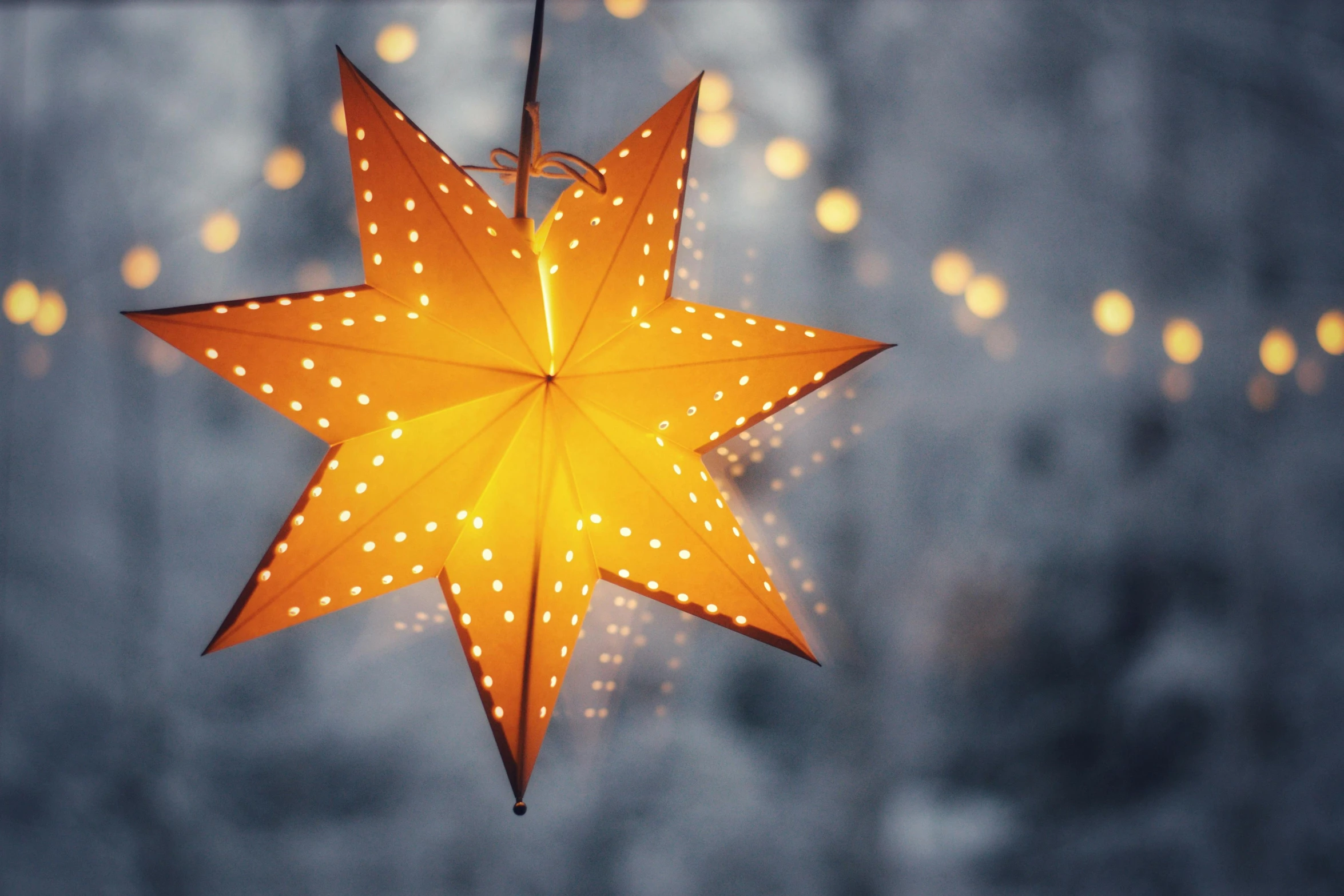a lighted star hanging from a string of lights, a photo, by Julia Pishtar, trending on pexels, light and space, yellow lanterns, giant star, the light is bright and wintry, subtle detailing