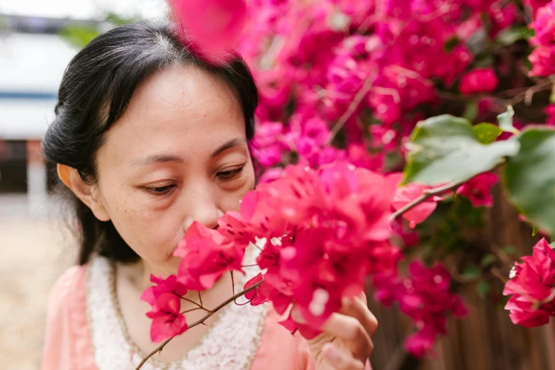 a woman smelling a bunch of pink flowers, inspired by Cui Bai, pexels contest winner, bougainvillea, avatar image