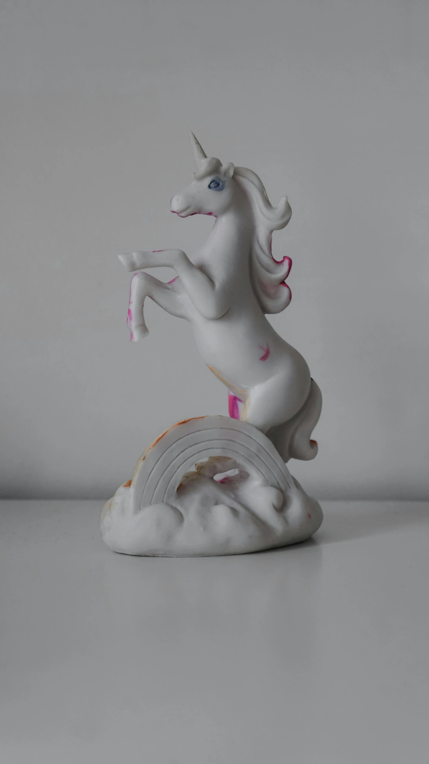 a figurine of a unicorn on top of a rainbow, a statue, new sculpture, white clay, shot on sony a 7, grey, low quality photo