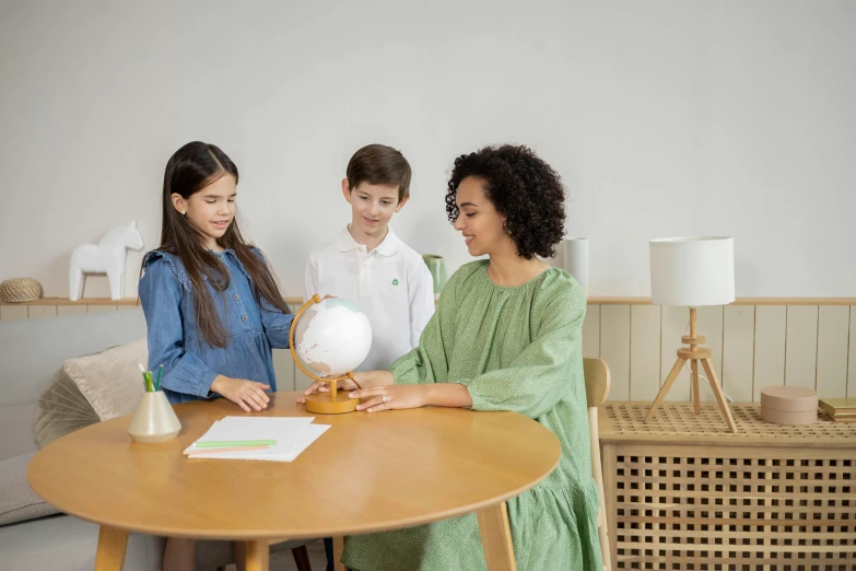 two women and a boy looking at a globe on a table, pexels contest winner, interactive art, barometric projection, high quality product photo, hammershøi, medium height