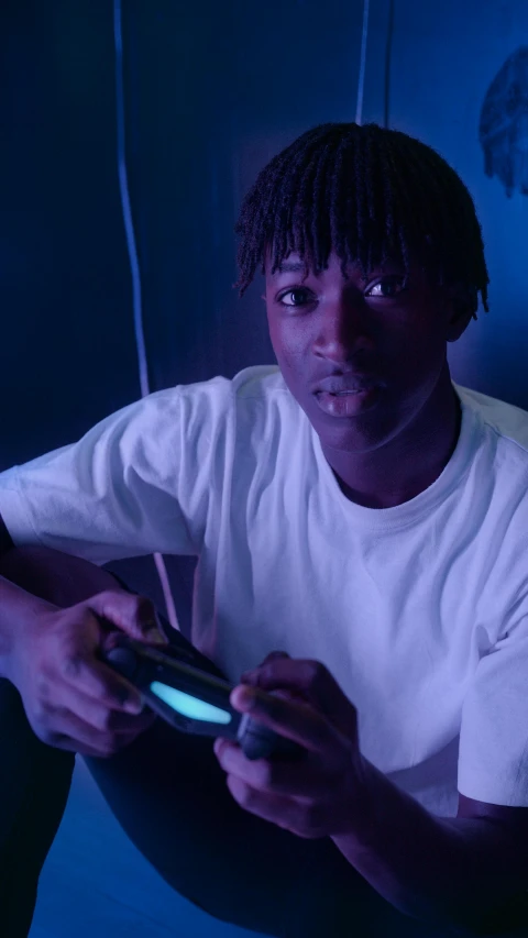 a man in a white shirt is playing a video game, by Maxwell Bates, pexels contest winner, playboi carti portrait, glowing blue, black teenage boy, instagram post