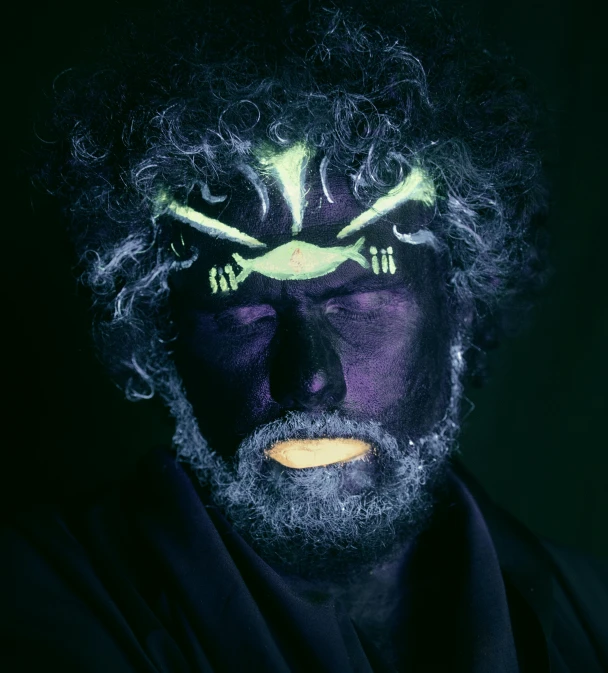 a close up of a person with a weird face, by Thomas Bock, unsplash, afrofuturism, glow in dark, gray beard, thanos as frodo baggins, with haunted eyes and curly hair