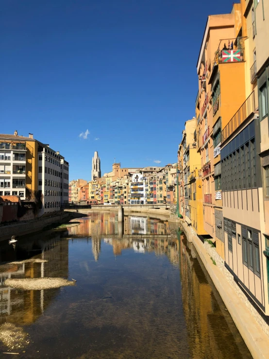 a river running through a city next to tall buildings, a picture, inspired by Modest Urgell, cloicsonne, looking towards camera, golden, thumbnail