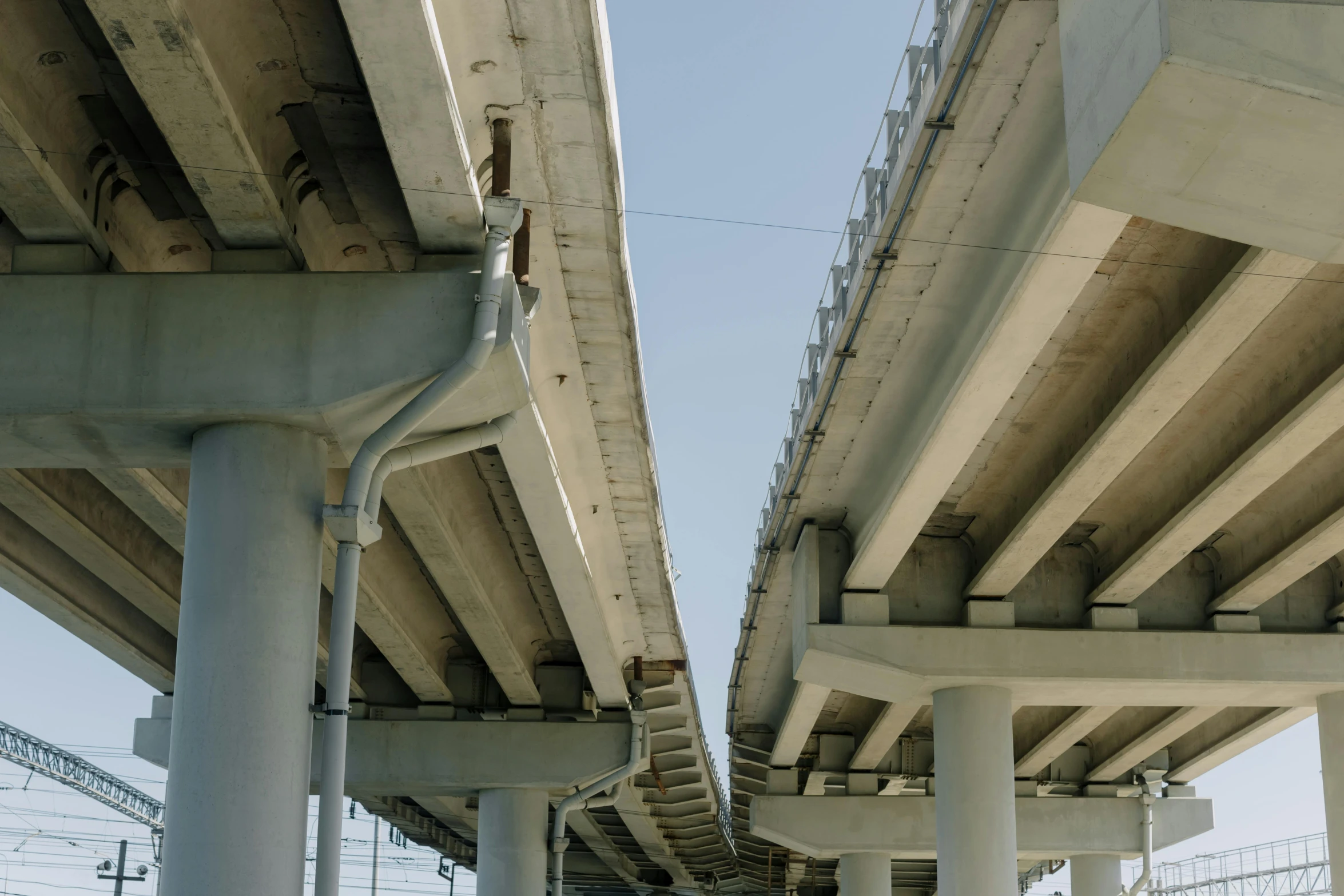 a couple of bridges that are next to each other, an album cover, by Carey Morris, unsplash, renaissance, steel pipes, highways, jr sc maglev, side view close up of a gaunt