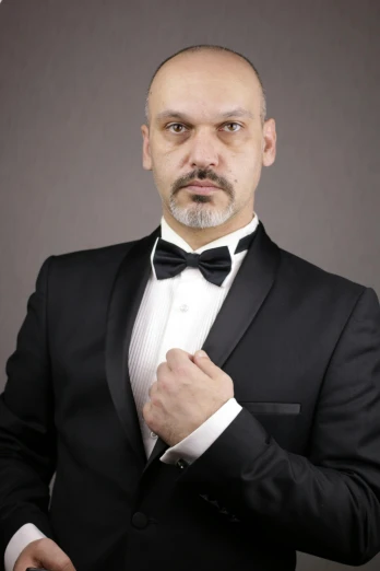 a man in a tuxedo poses for a picture, inspired by Edi Rama, reddit, posing ready for a fight, profile image, rugged man portrait, professional profile photo