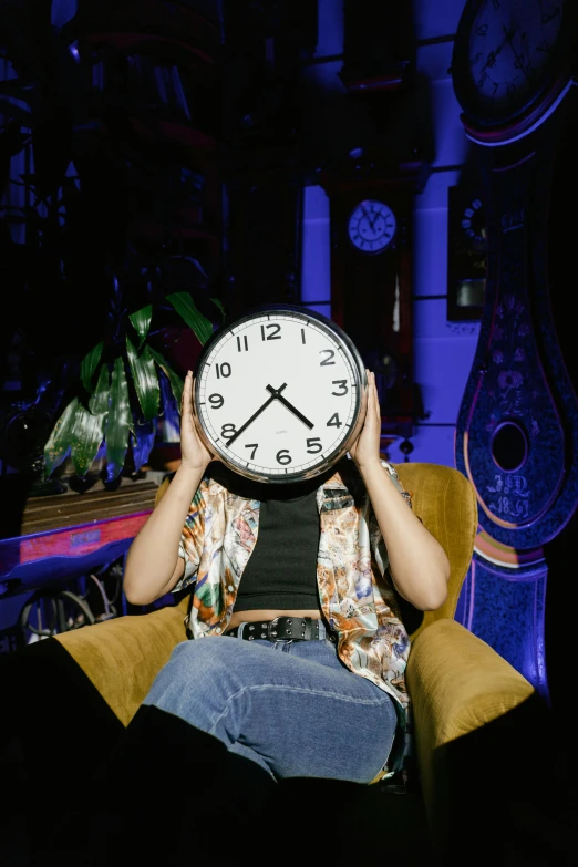 a woman sitting in a chair holding a clock in front of her face, inspired by Elsa Bleda, maximalism, digital image, 2000s photo, clocks, gen z