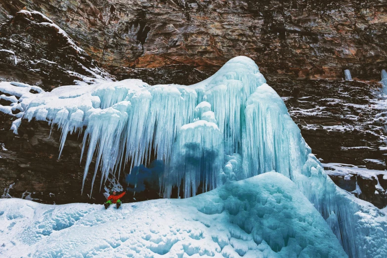 a person standing in front of a frozen waterfall, by Kristin Nelson, pexels contest winner, hurufiyya, deep colours. ”, stalactites, thumbnail, climbing