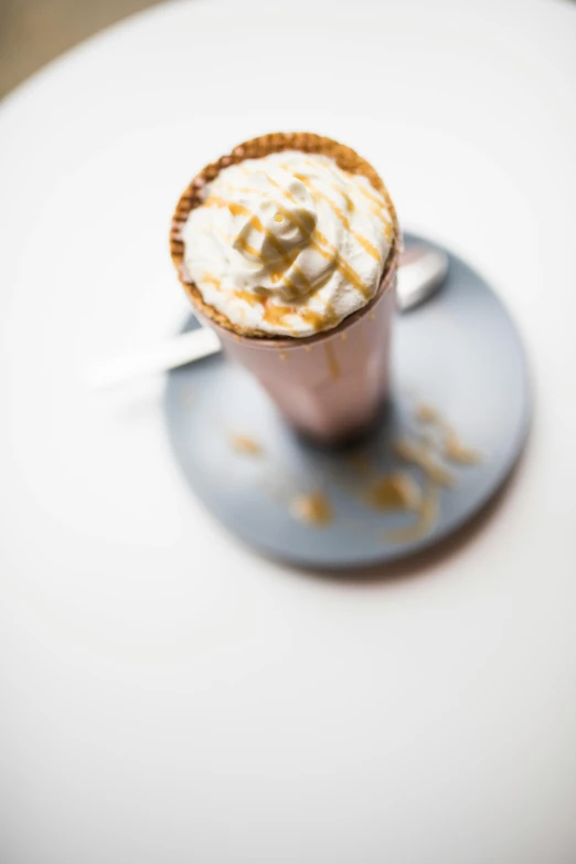 a cup of coffee sitting on top of a saucer, milkshake, caramel, thumbnail, tall shot