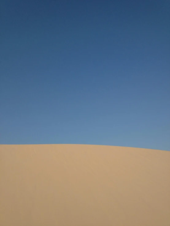 a person standing on top of a sand dune, by Peter Churcher, postminimalism, with blue light dark blue sky, square, july 2 0 1 1, light tan